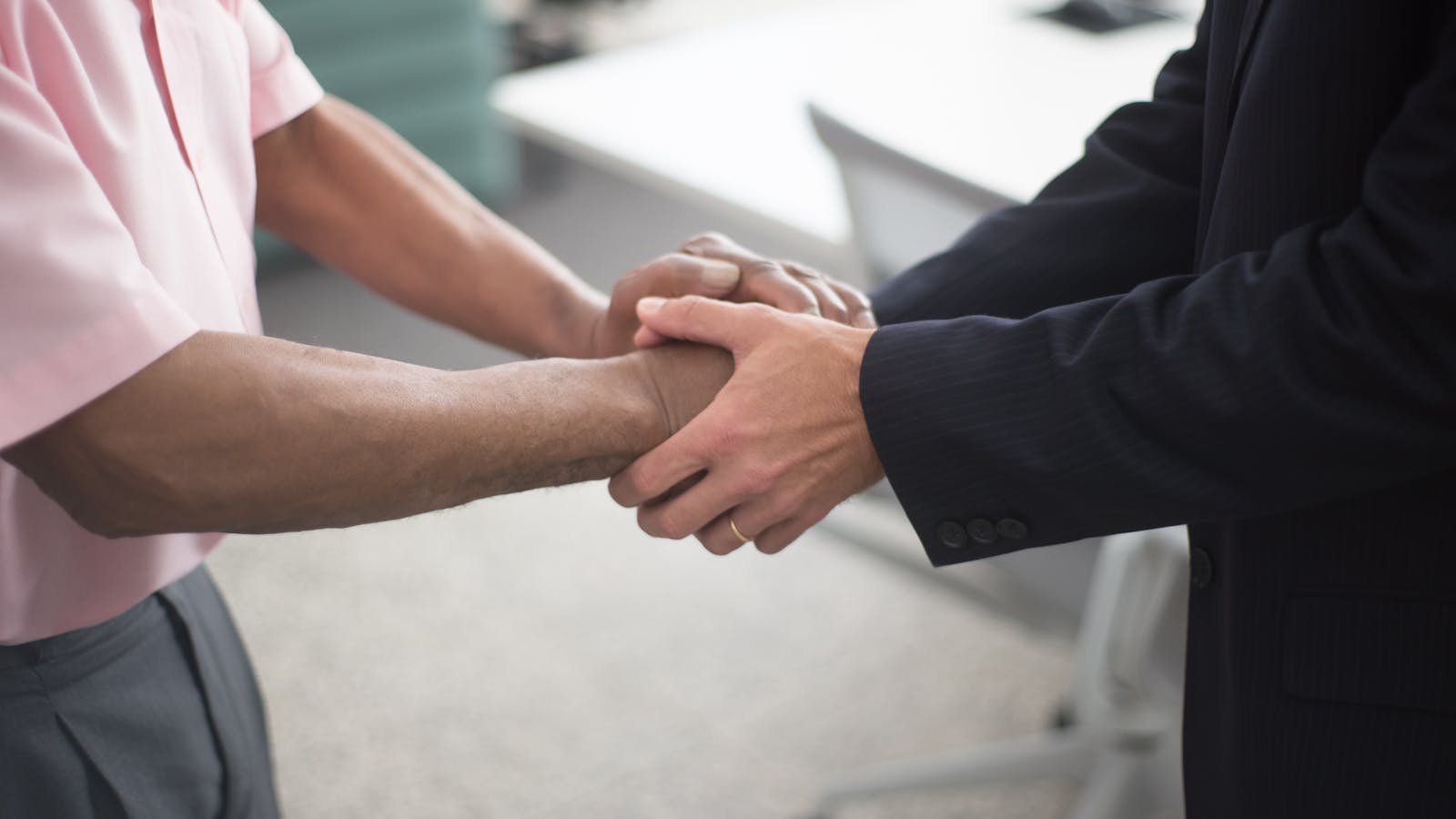 Two business professionals signing a corporate acquisition agreement
